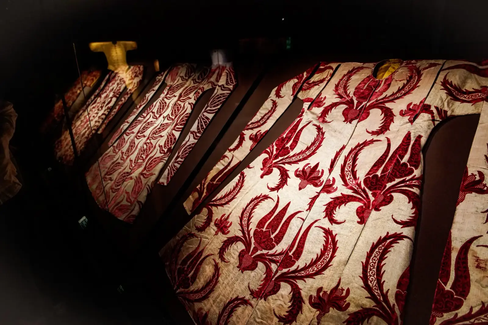 A silk imperial kaftan woven in red and cream, in the sultans' costume gallery.