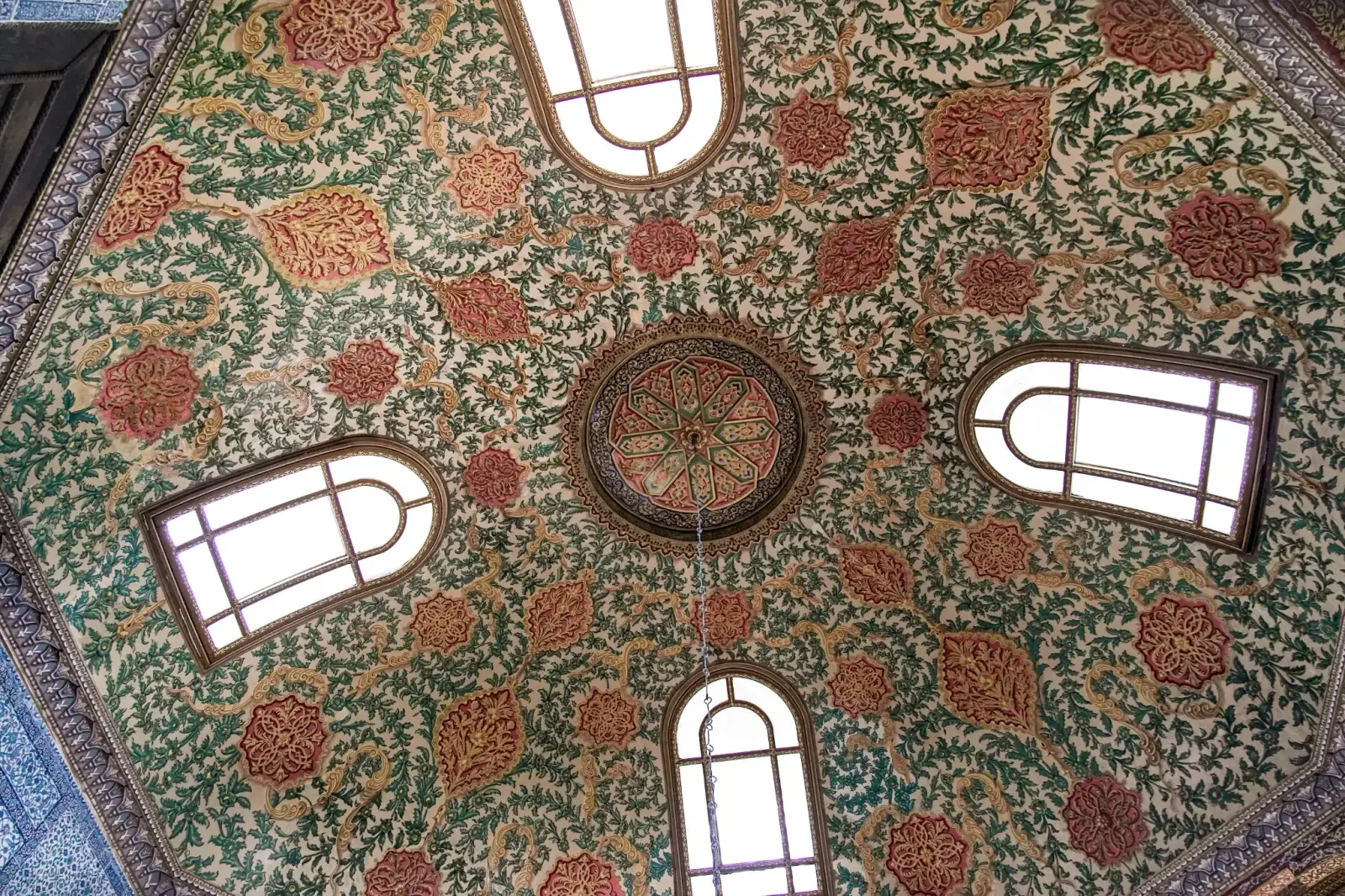 A painted dome in the Fourth Courtyard, floral medallions in red, green and gold around the windows.