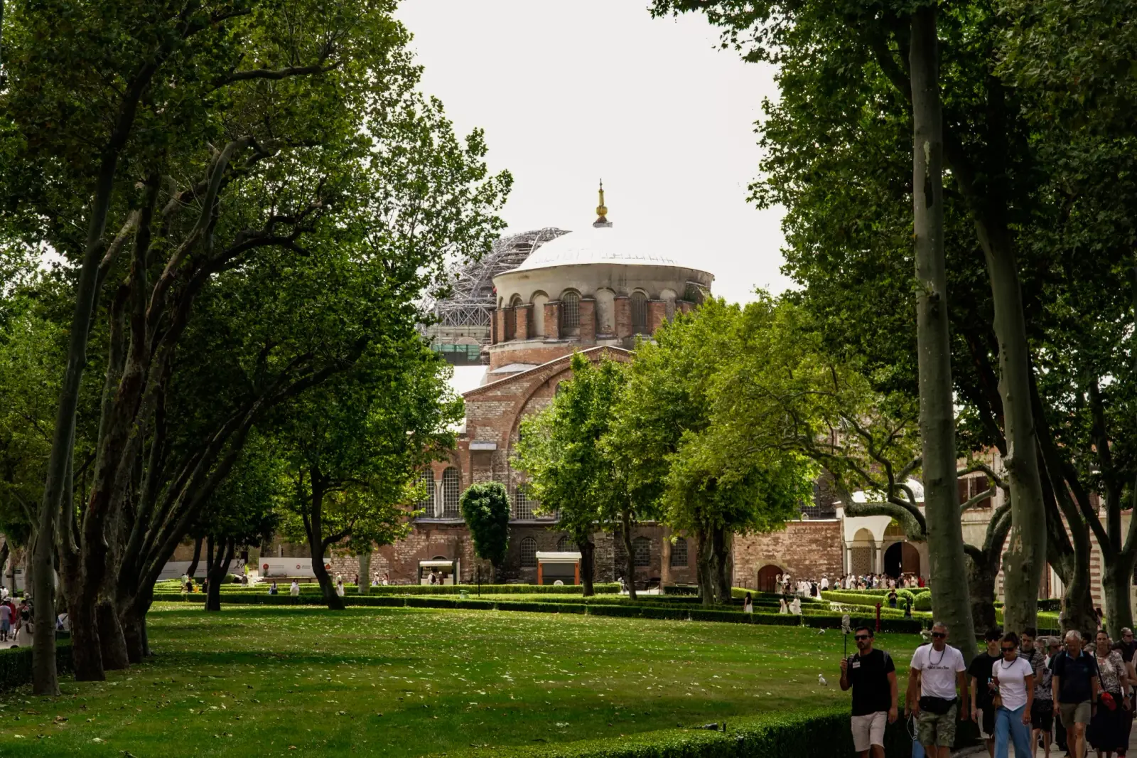 Hagia Irene seen across the lawns of the First Courtyard, framed by plane trees.