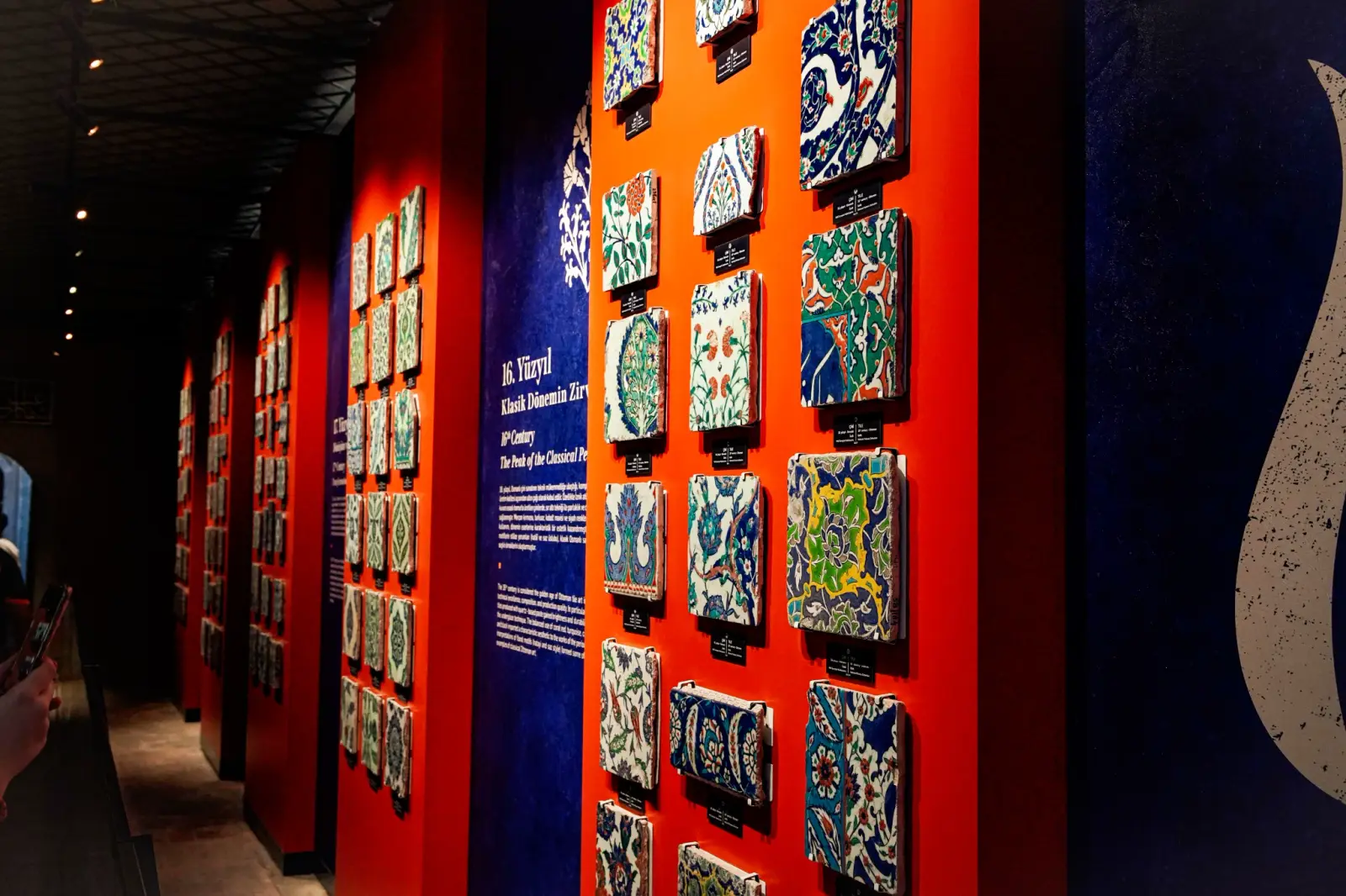 İznik tiles displayed on the red walls of the palace tile gallery.