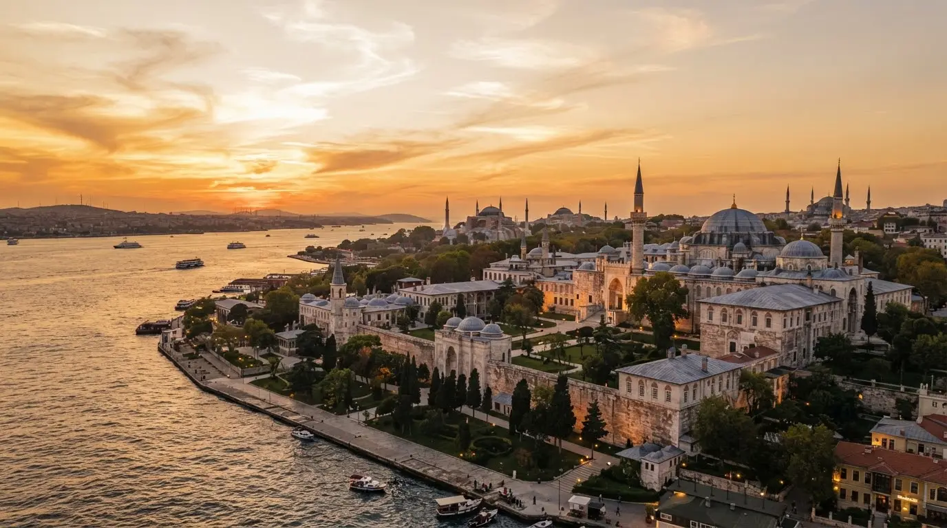 The Topkapi Palace complex at sunset, domes and minarets against a golden Istanbul sky with the Marmara Sea beyond.