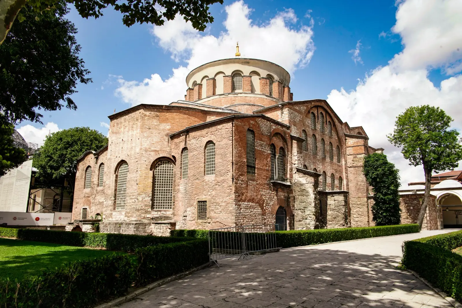 Hagia Irene from the south, its brick apse and lead dome above clipped hedges.