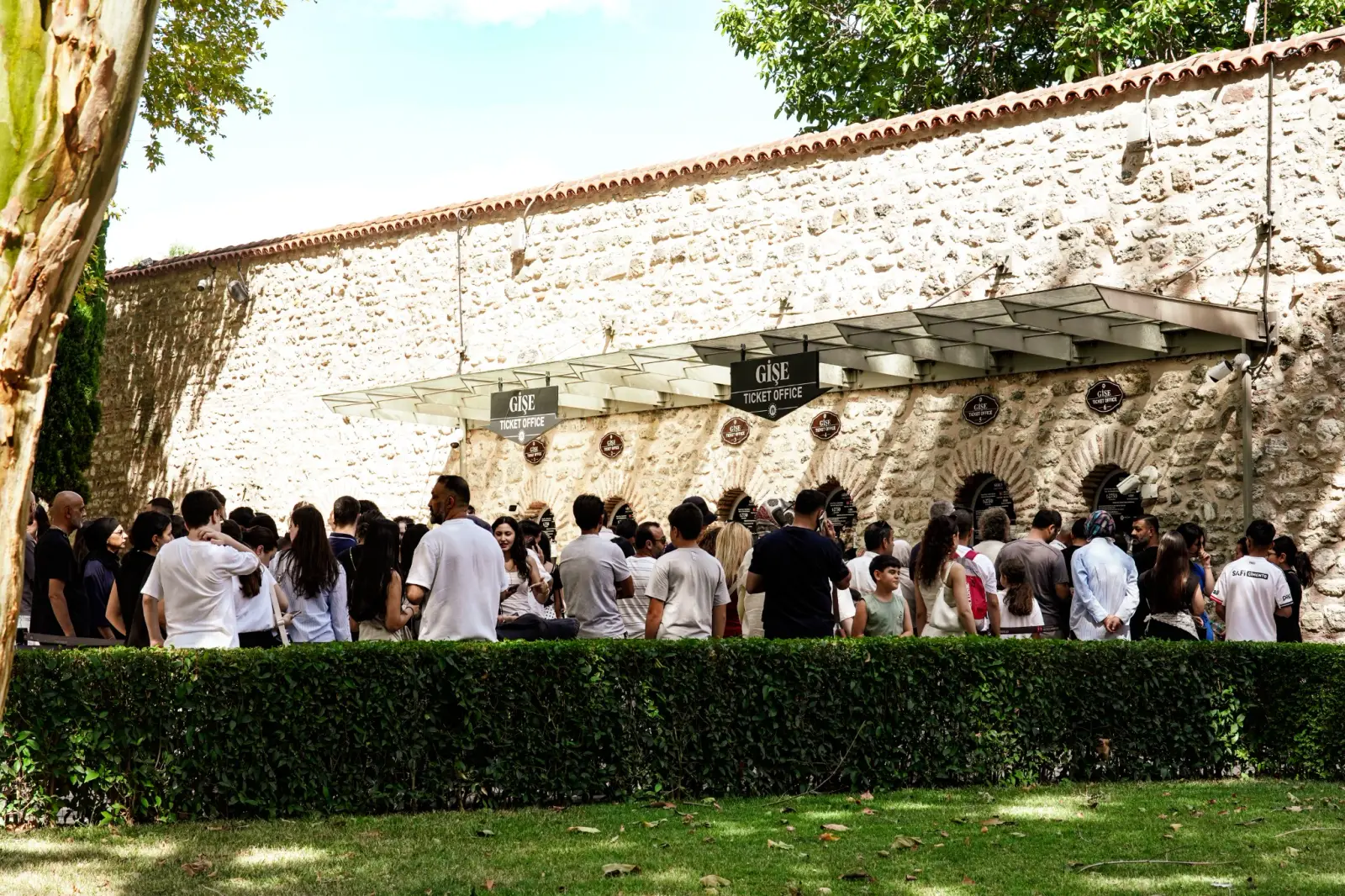 The ticket-office range in the First Courtyard, arched counters beneath a tiled roof.