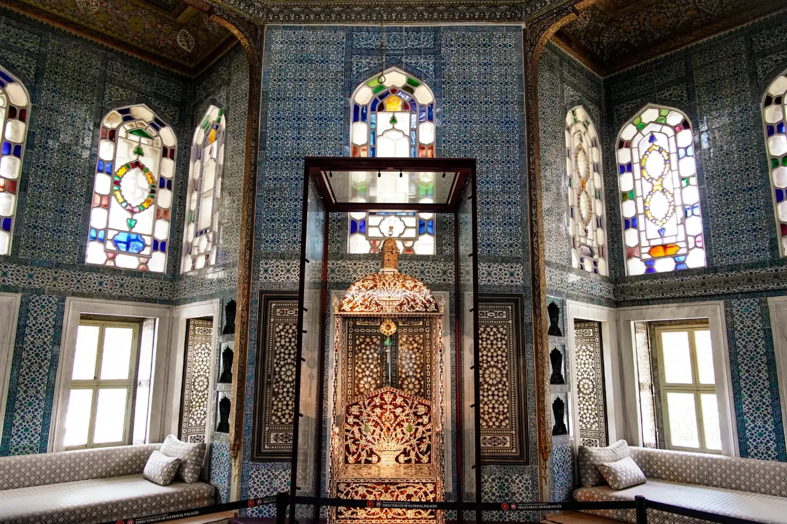 Inside the Revan Pavilion: İznik tiles, stained glass and an inlaid cabinet beneath the dome.
