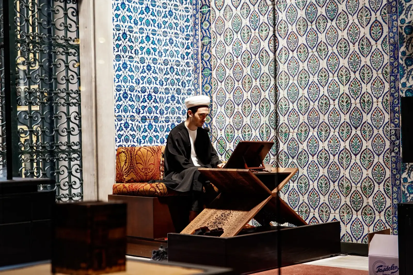 A reciter at a rahle in the Privy Chamber, continuing the recitation of the Quran kept up here for five centuries.