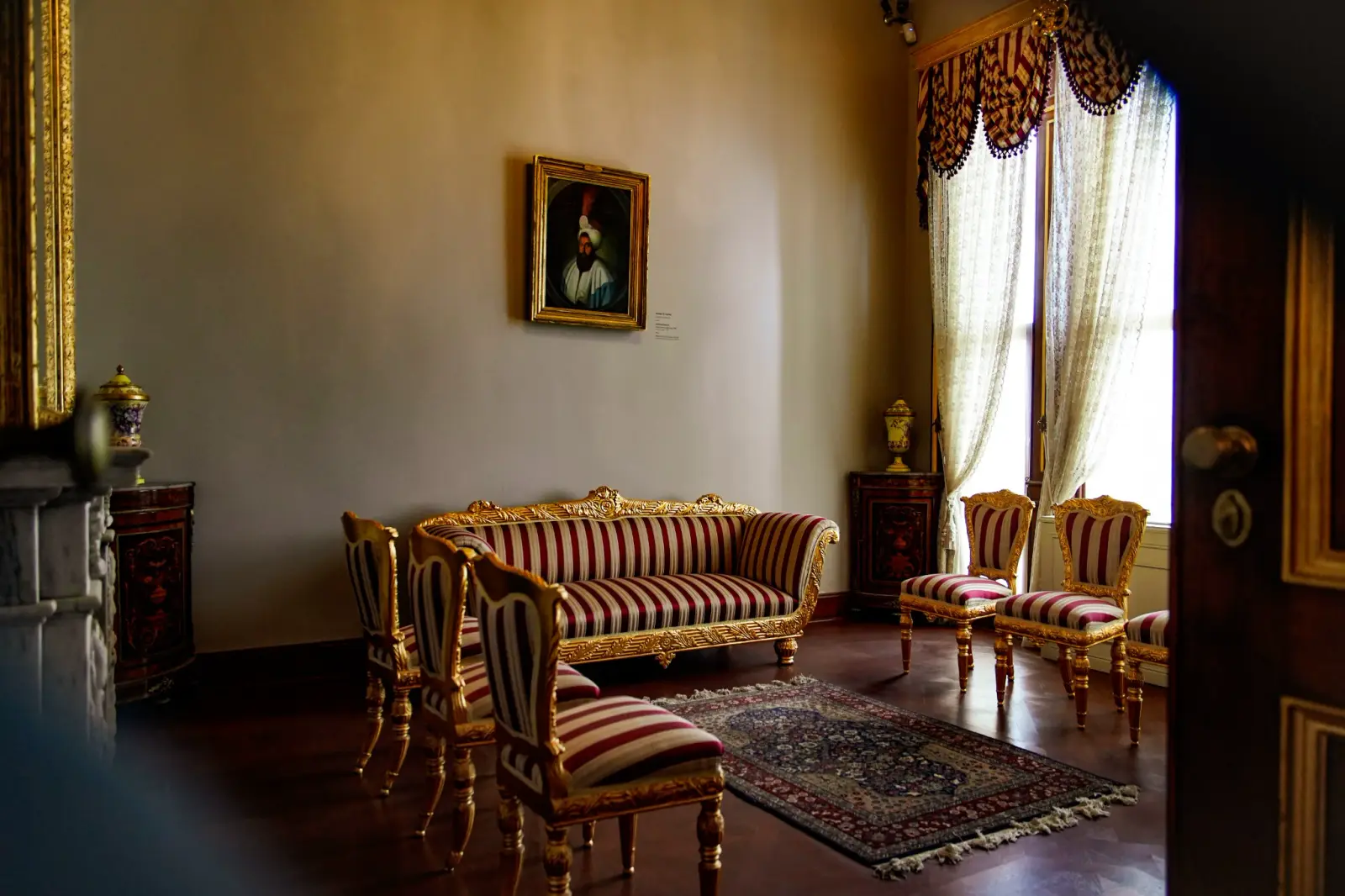 A nineteenth-century Harem salon — striped upholstery and a framed portrait, the European taste of the late court.