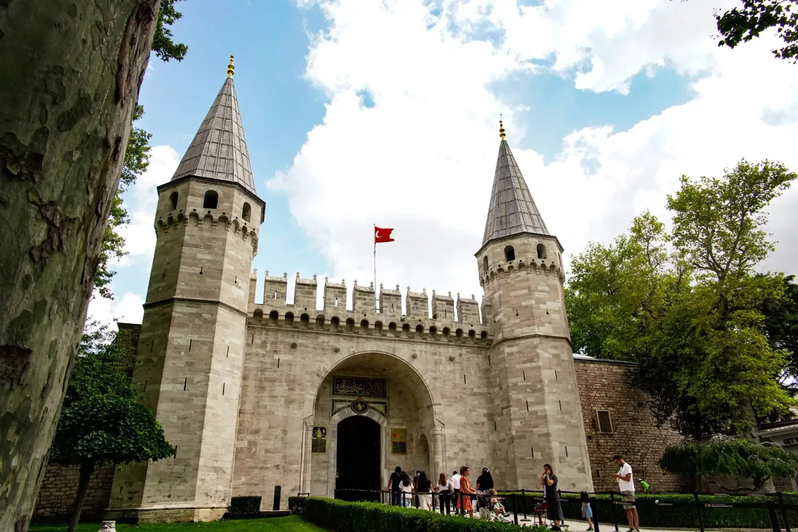 The Gate of Salutation, its two conical towers and crenellated wall under a summer sky.
