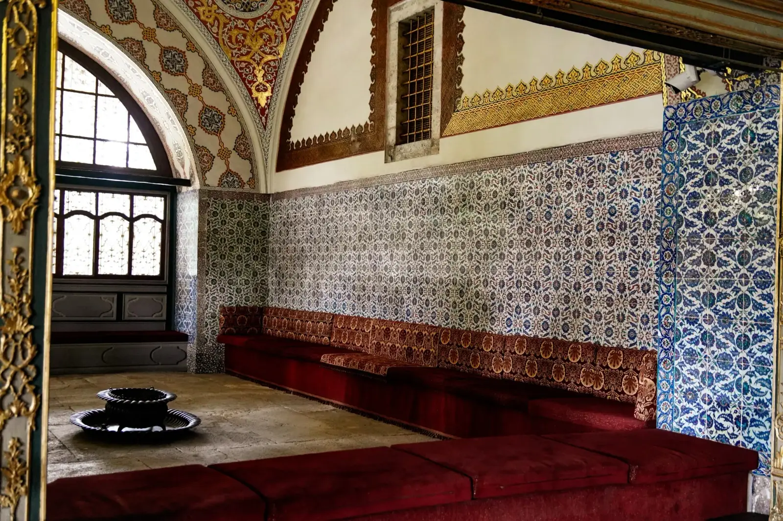 Inside the Imperial Council chamber: İznik tiles above the low red divan where the viziers sat.